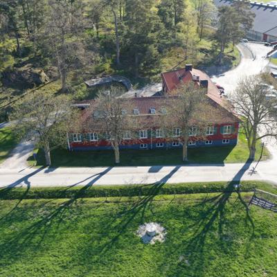 Aerial view of Hamra Conference Centre, a red wooden building originally built in 1943 as Lantmannaskolan and now used for conferences, surrounded by trees and rural landscape.
