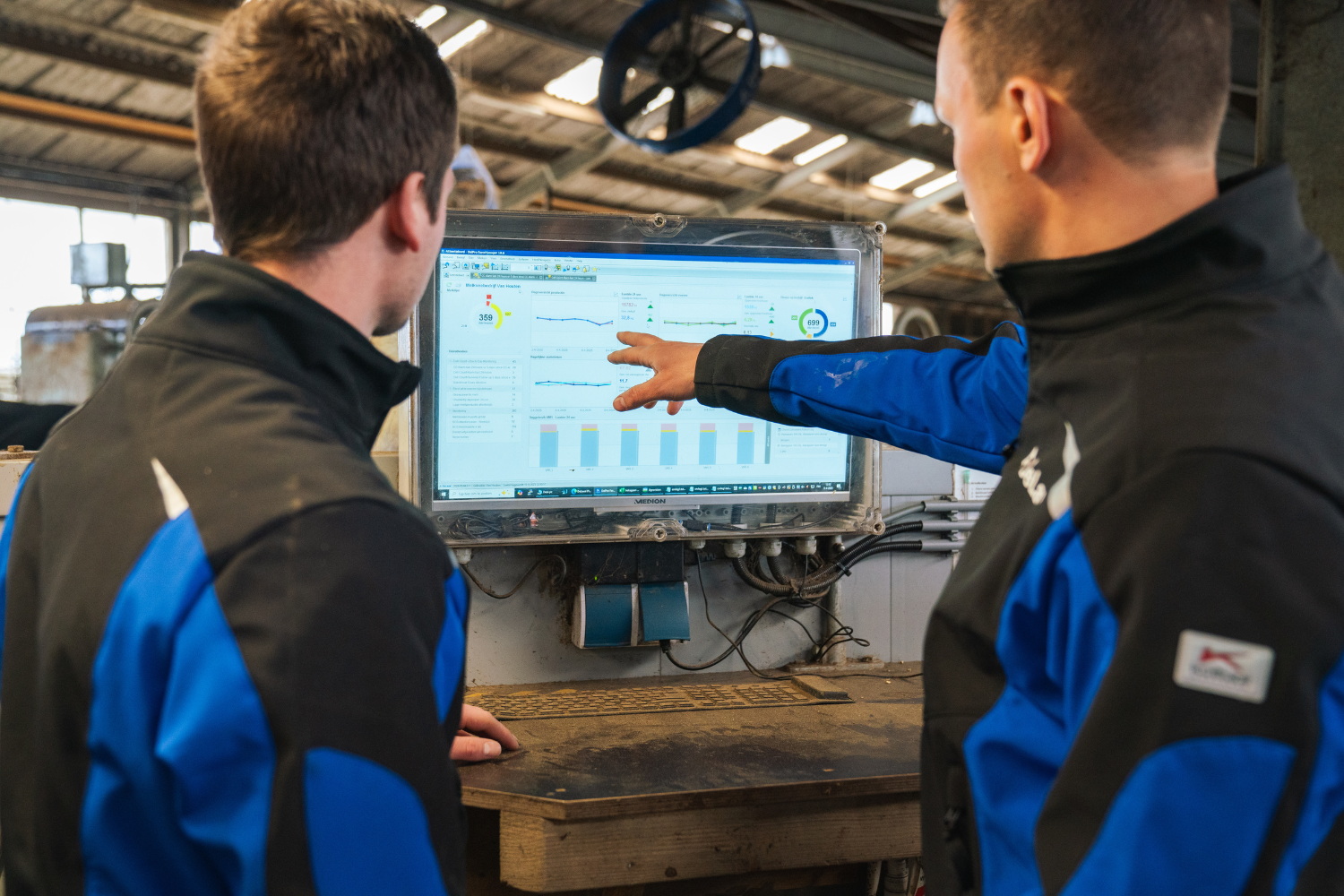 Melkveehouders Arjan en Theo van Houten bij een computerscherm waar ze resultaten van DeLaval Milk Cell Analysis analyseren