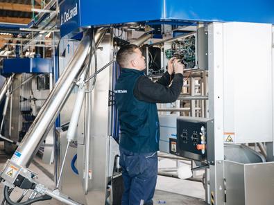 Técnico de servicio DeLaval trabajando en un robot de ordeño DeLaval VMS Técnico de servicio DeLaval trabajando en un robot de ordeño DeLaval VMS